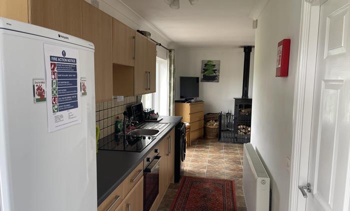 Shows fridge freezer, kitchen wall and base cabinets, ceramic hob, single electric oven, sink, washing machine, radiator and French doors.